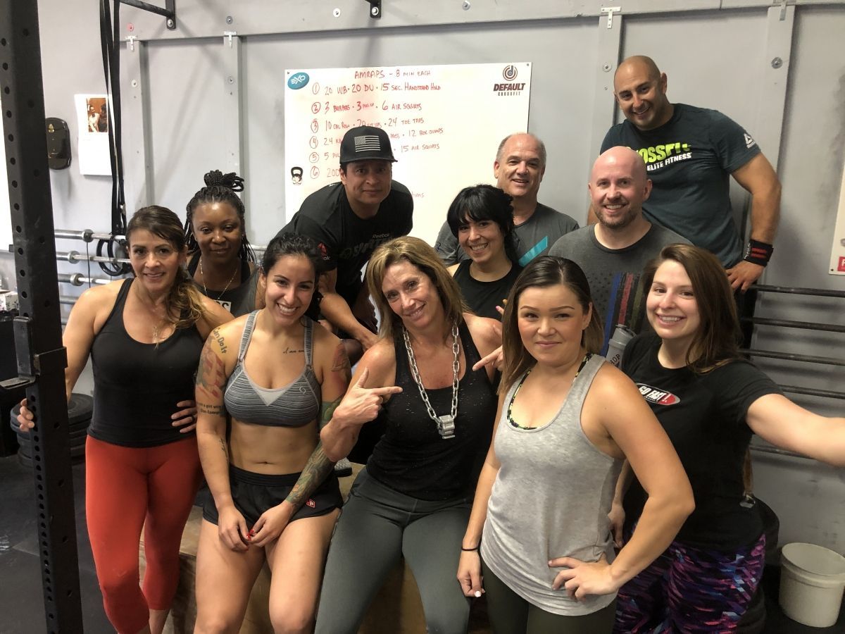 A group of people are posing for a picture in a gym.