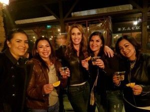 A group of women are standing next to each other holding drinks.