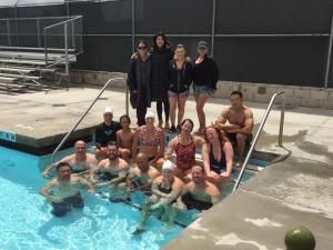 A group of people are posing for a picture in a swimming pool.