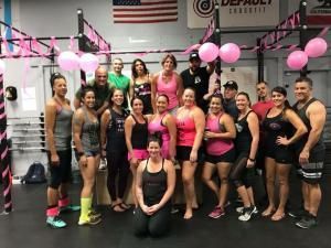 A group of people are posing for a picture in a gym.