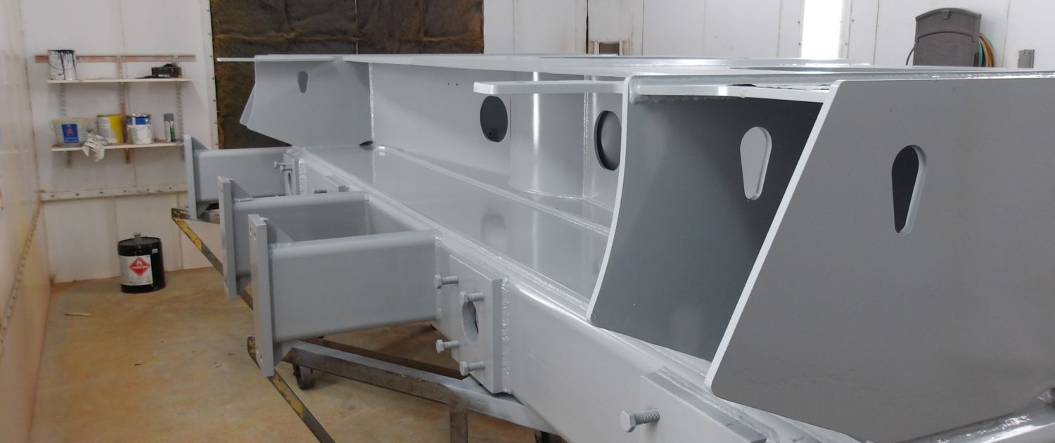 A large gray metal structure inside a light-colored room with shelves and a container.