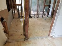 A room with a wooden floor and a measuring tape in it.