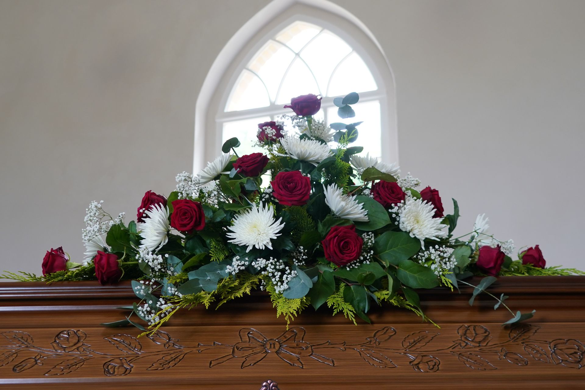 Coffin with flowers above.