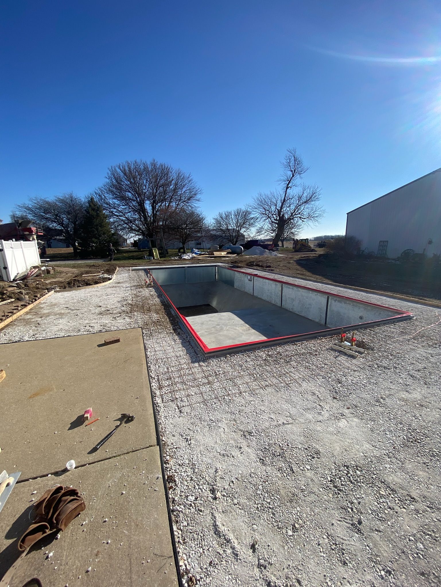 A swimming pool is being built in the backyard of a house.