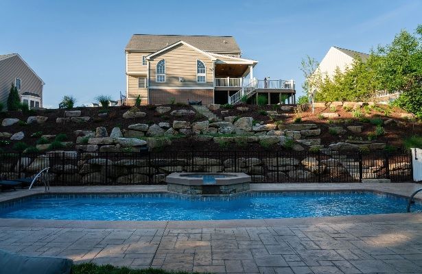A large swimming pool with a house in the background.