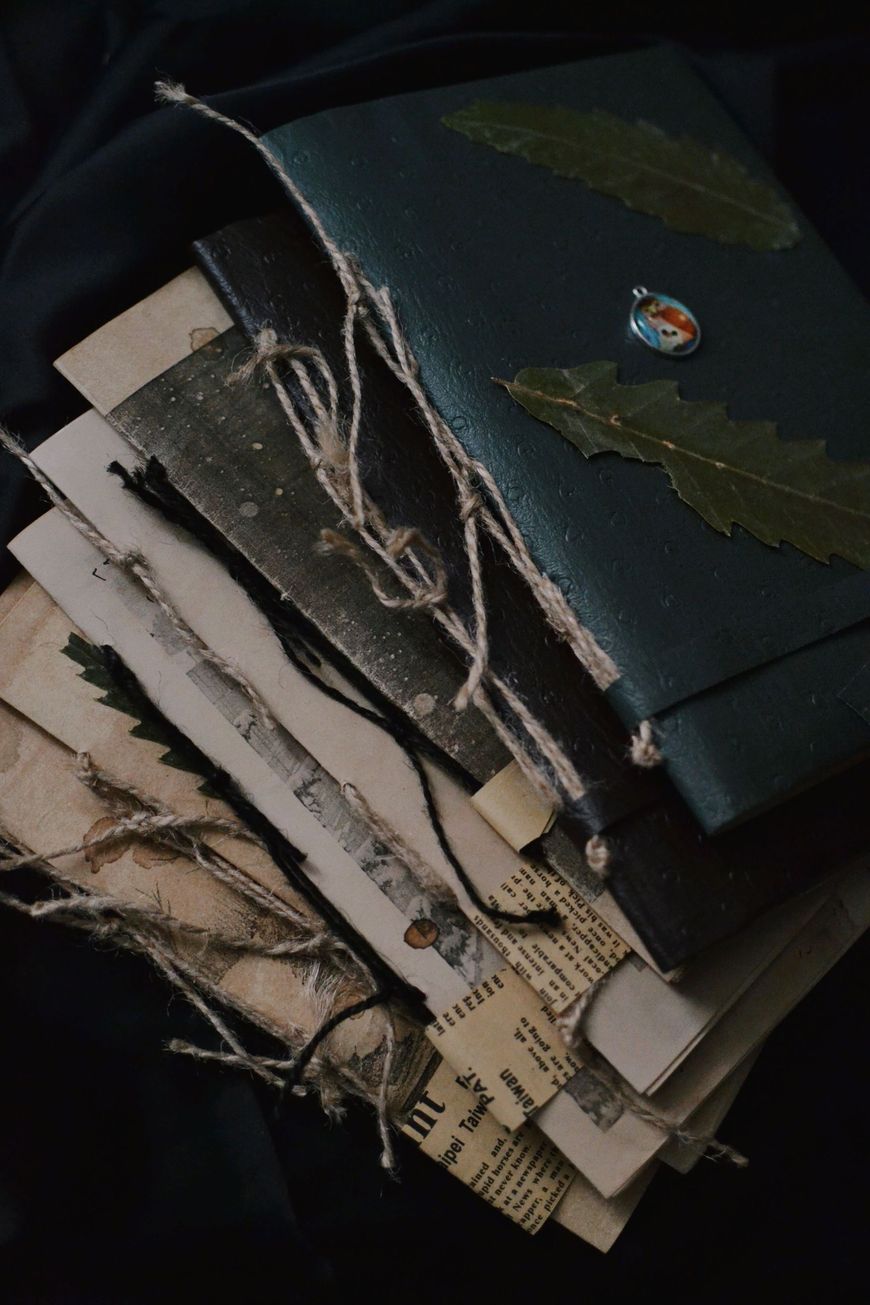Stack of folded fabric swatches in muted gray, black, and green tones with visible stitching and frayed edges