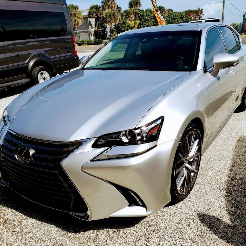 Silver Lexus sedan parked outdoors on a sunny street, front three-quarter view