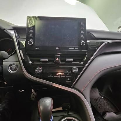 Car dashboard and center console with touchscreen display, climate controls, and gear shifter