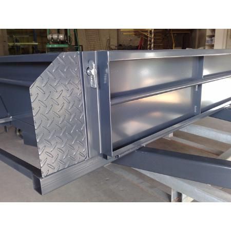 Gray metal toolbox with diamond plate details on a trailer frame.