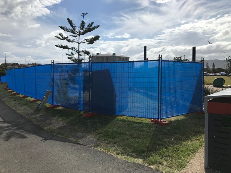 A Blue Temporary Fence is Surrounding a Construction Site — Coffs Coast and Country Temp Fence in Sapphire Beach, NSW