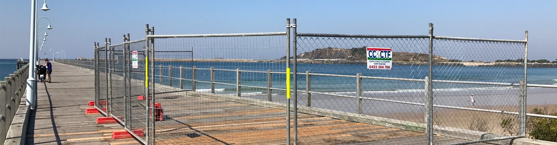 A Temporary Fence Surrounds a Pier Leading to the Ocean — Coffs Coast and Country Temp Fence in Sapphire Beach, NSW