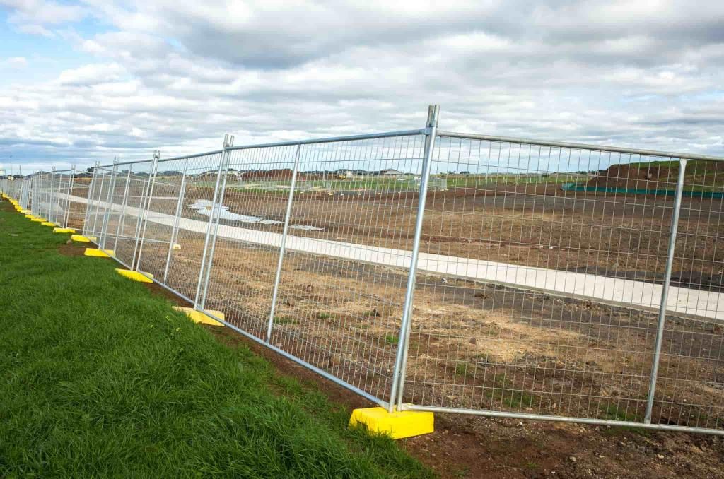 A Temporary Fence is Surrounding a Field of Grass and Dirt — Coffs Coast and Country Temp Fence in Sapphire Beach, NSW