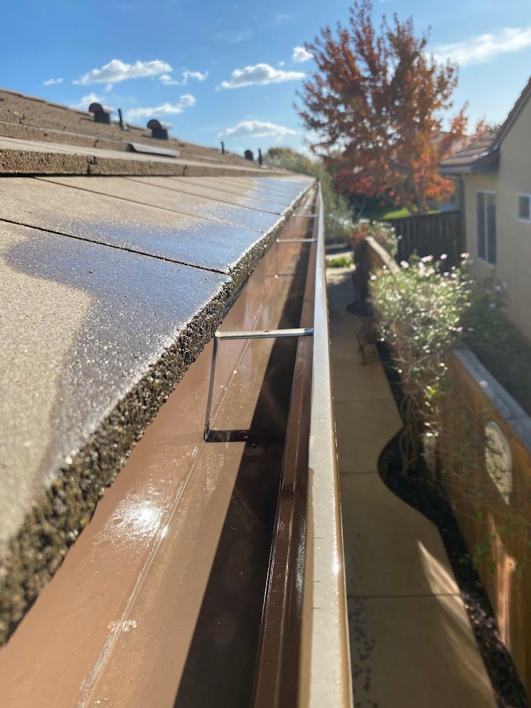 A gutter on the side of a house with a ladder attached to it.