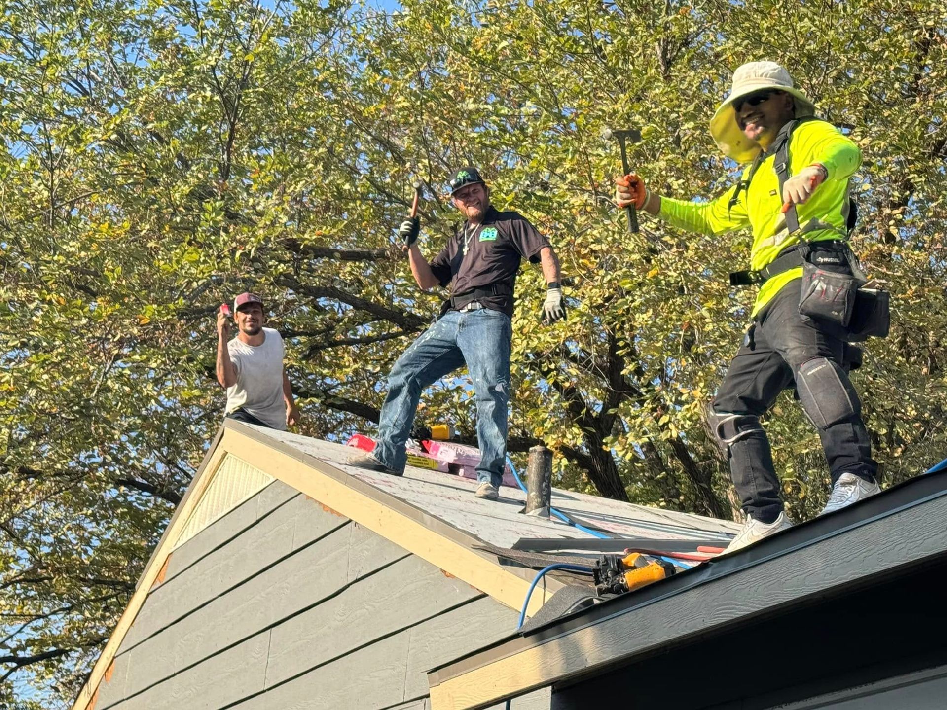 A group of men are working on the roof of a house.