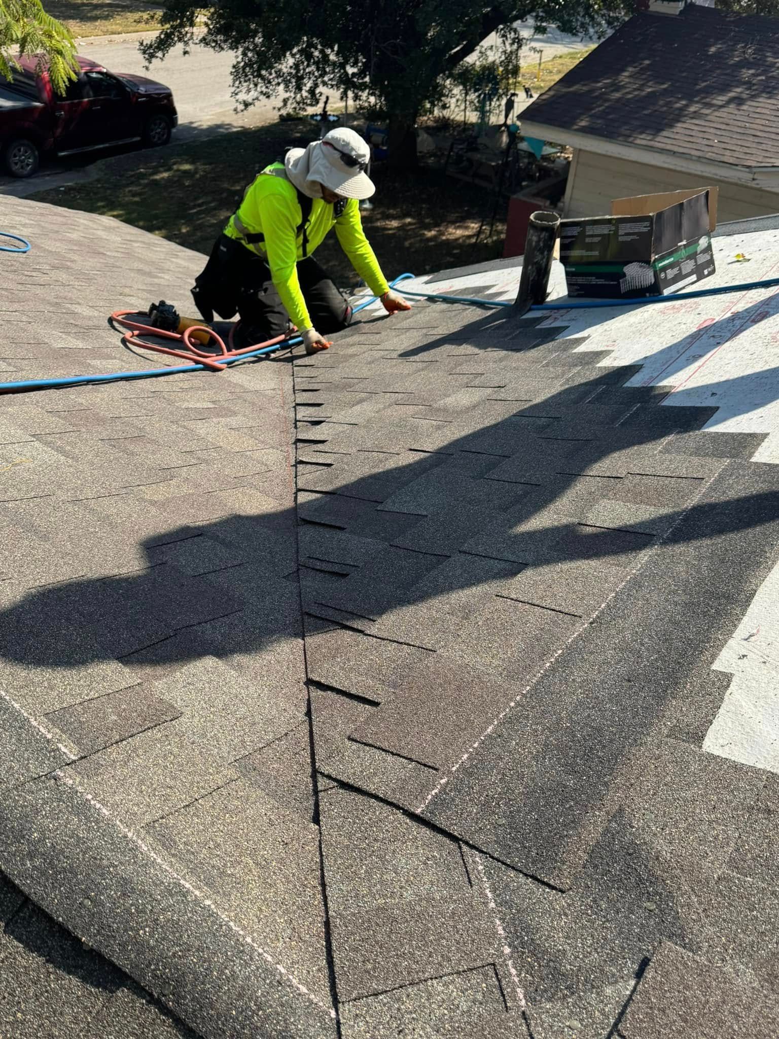 A man is working on the roof of a house.