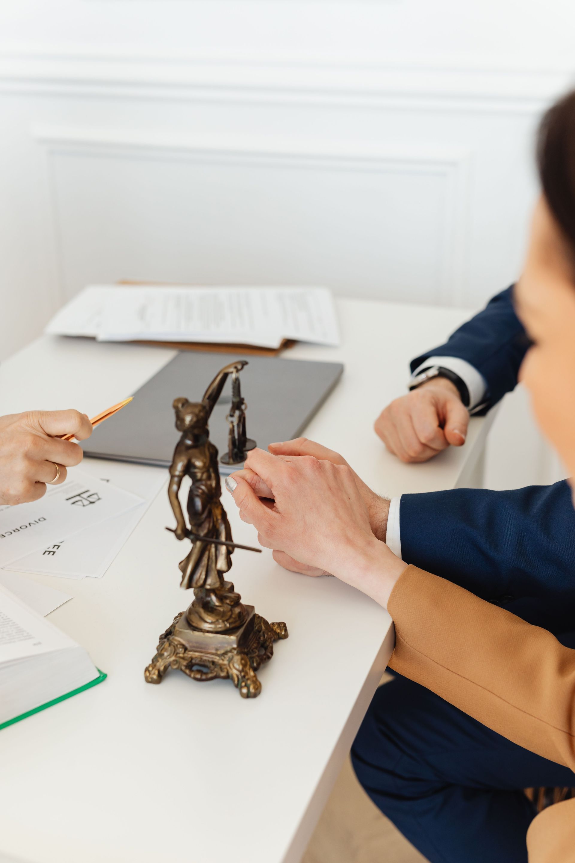 Hands examine a small bronze figurine on a white desk during an art or history lesson
