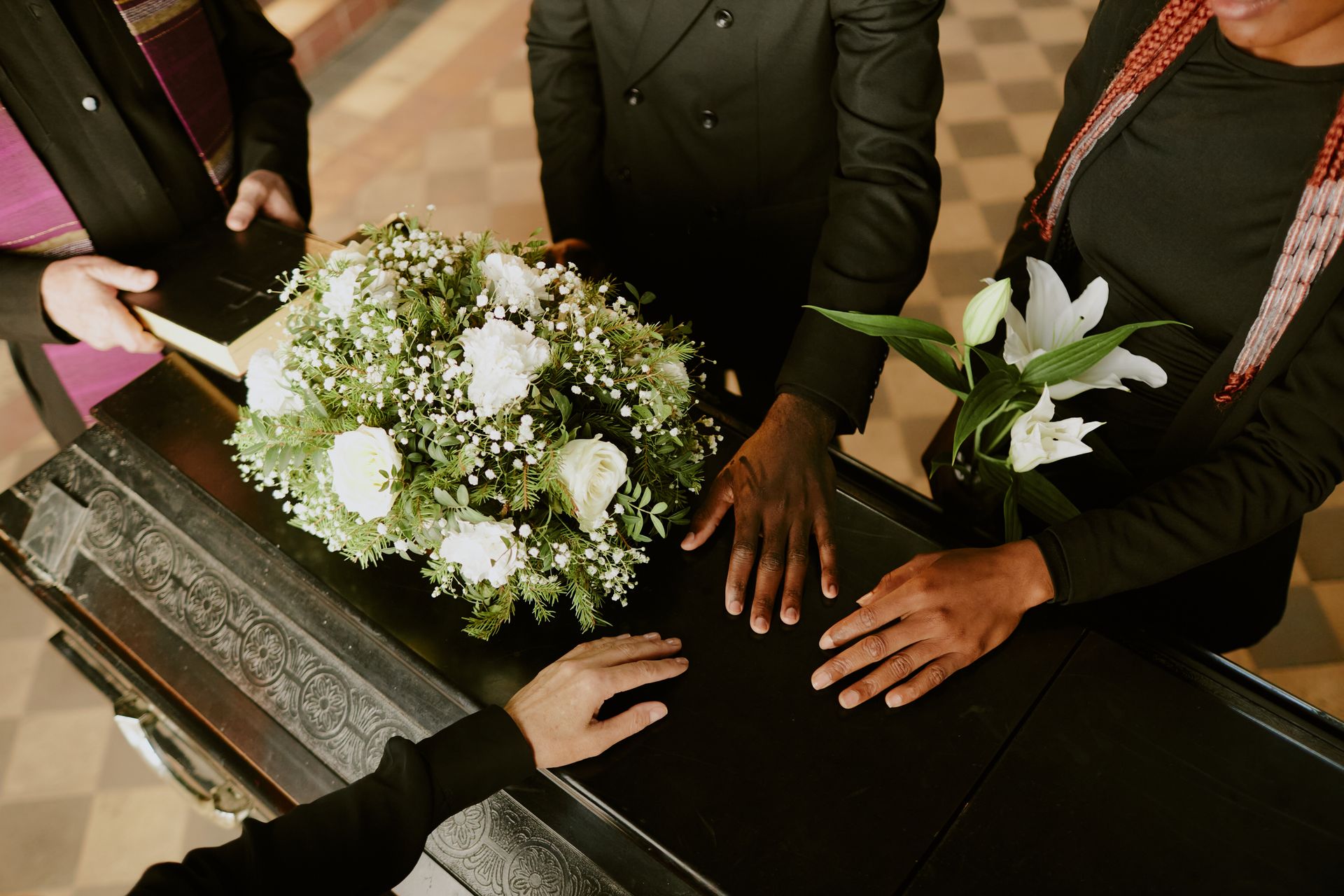 Hands around a bouquet on a wooden table during a wedding ceremony
