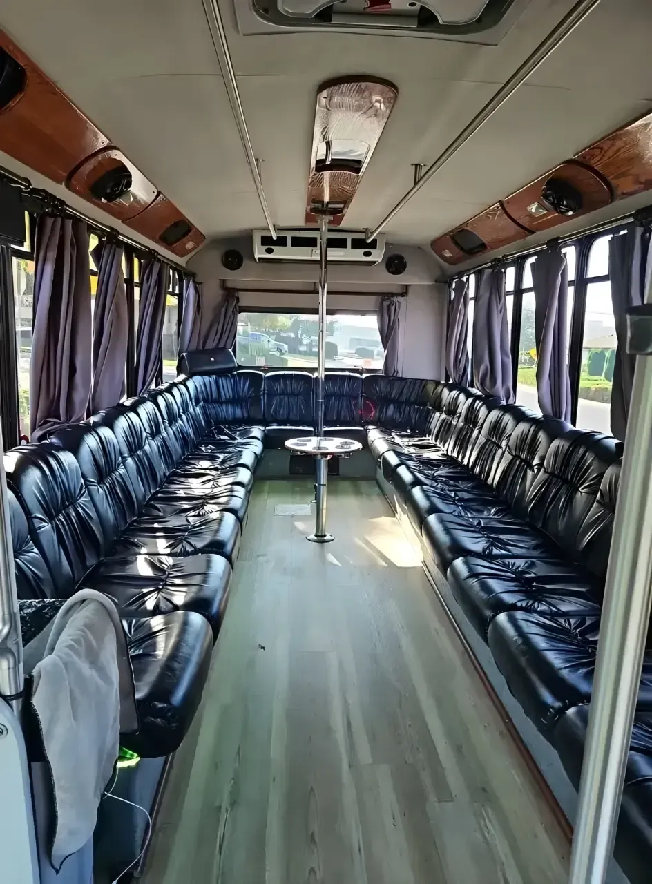 Empty bus interior with blue seats lining both sides and a central aisle.