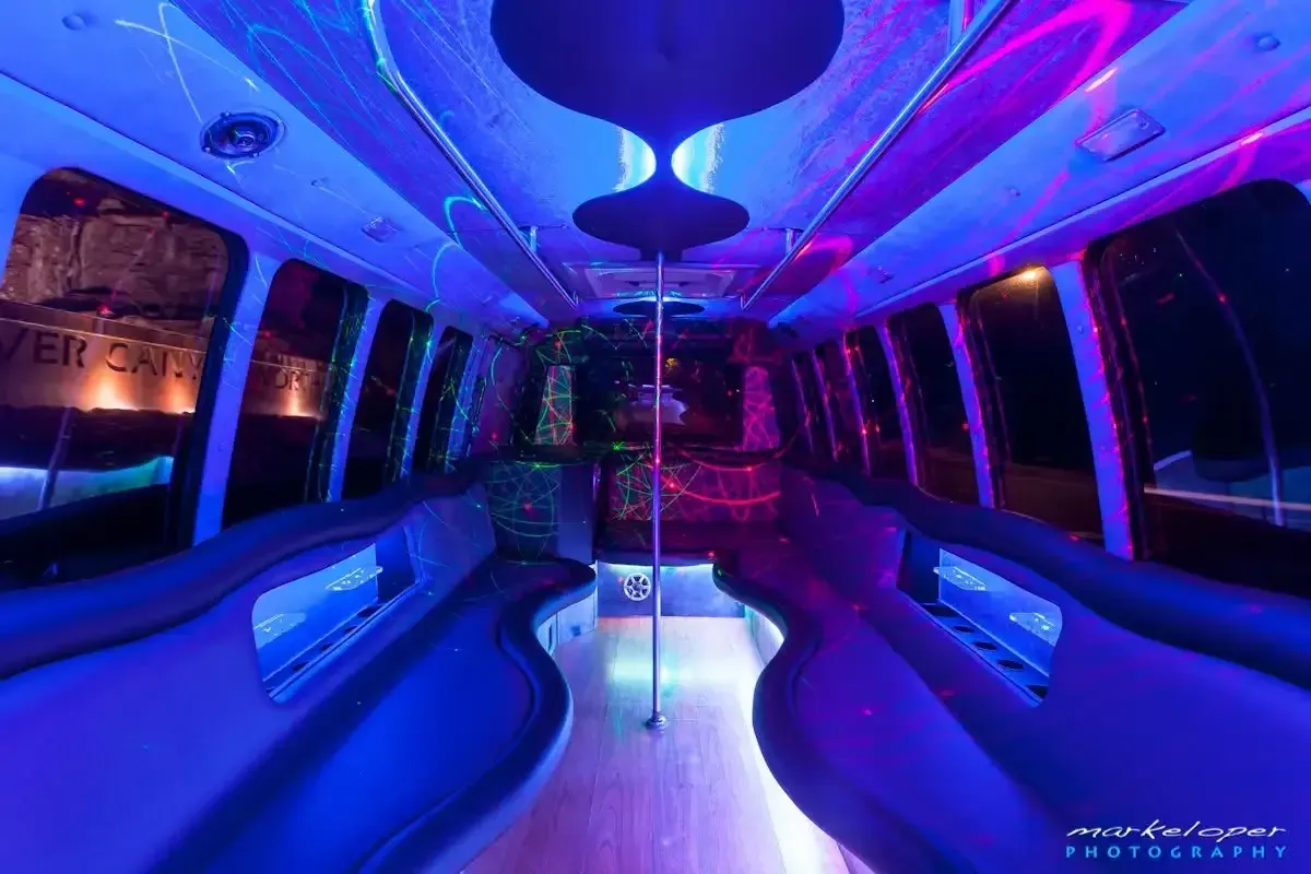 Neon-lit modern bus interior with blue and purple curved seating and reflective ceiling lights