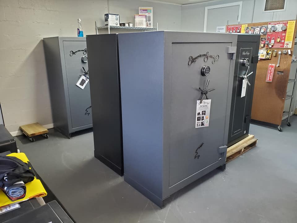 Several large safes of different colors displayed in a store setting.