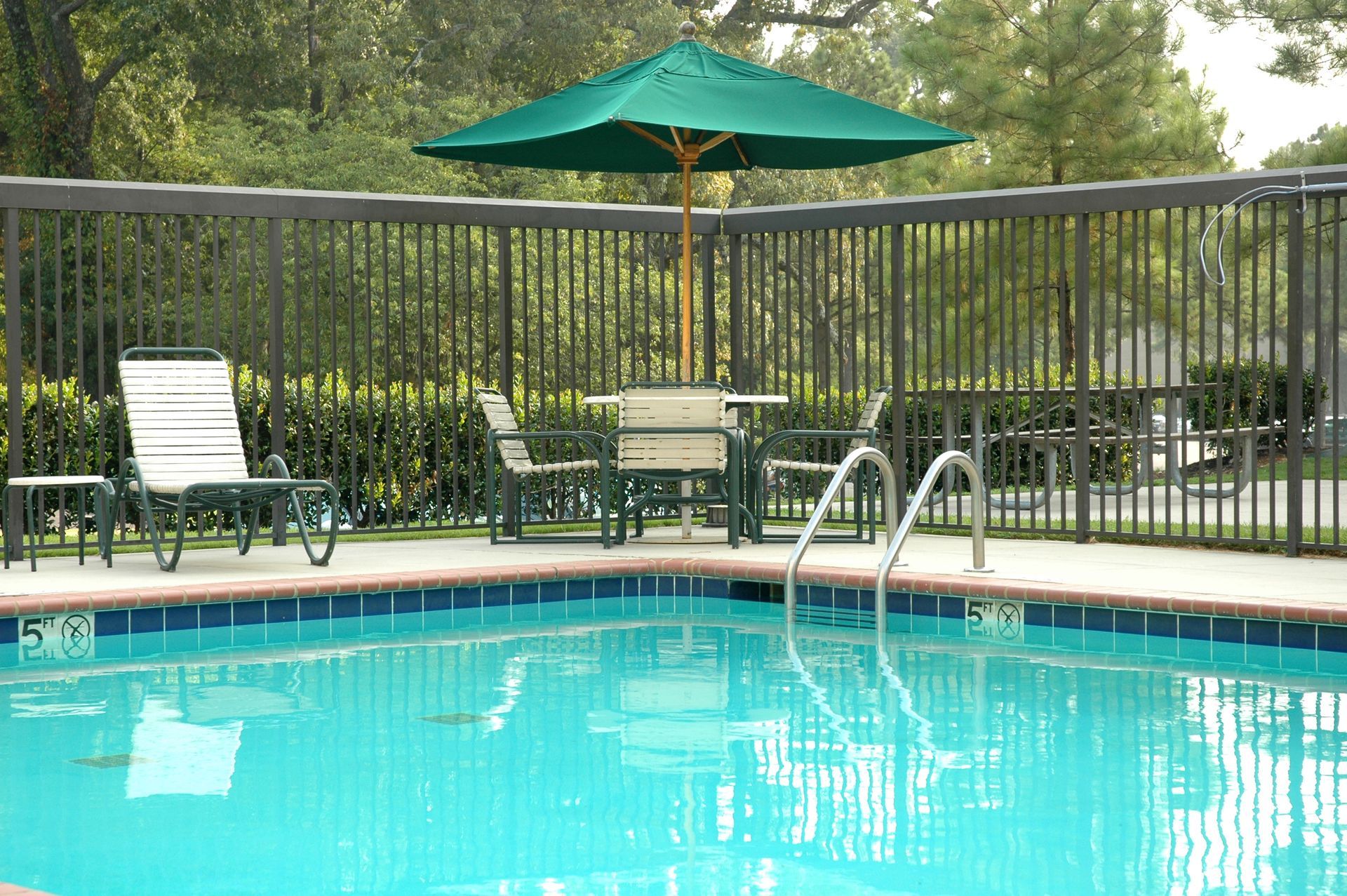 A Swimming Pool With a Blue Tiled Edge, Lounge Chair, and a Patio — Get My Pool Certified in Broadbeach Waters, QLD