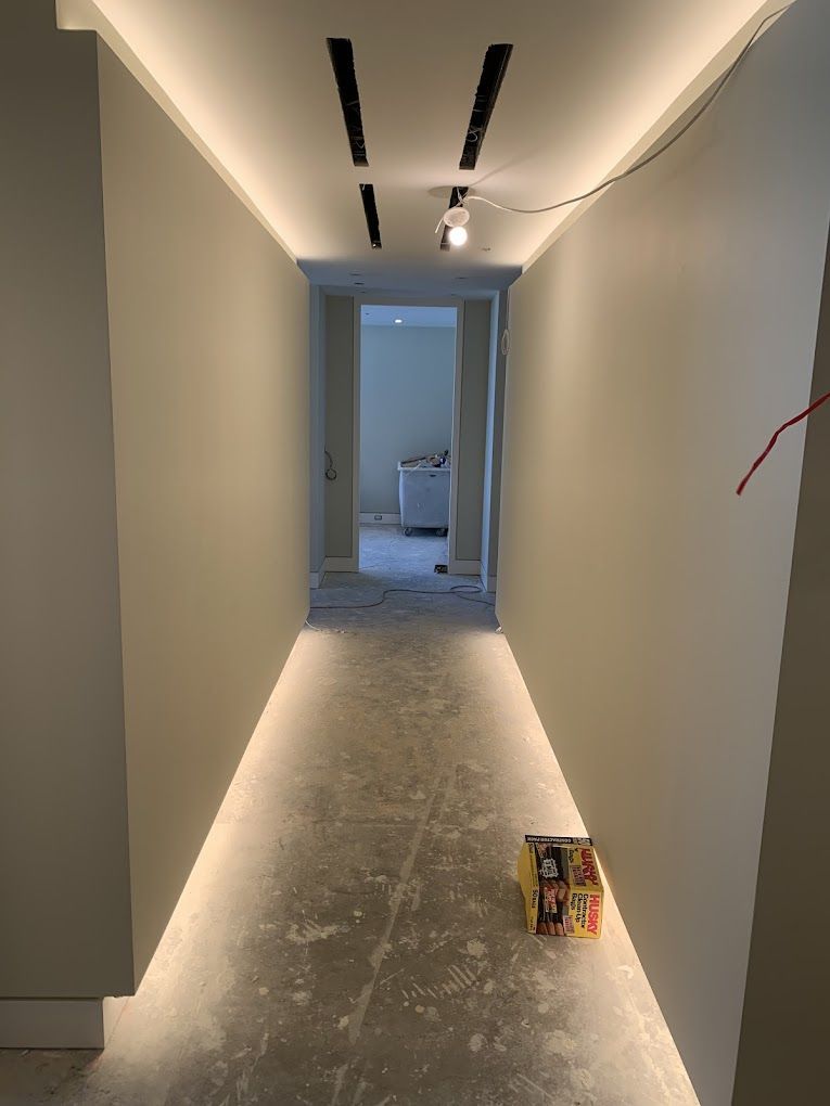 A long hallway with a lot of lights on the ceiling.