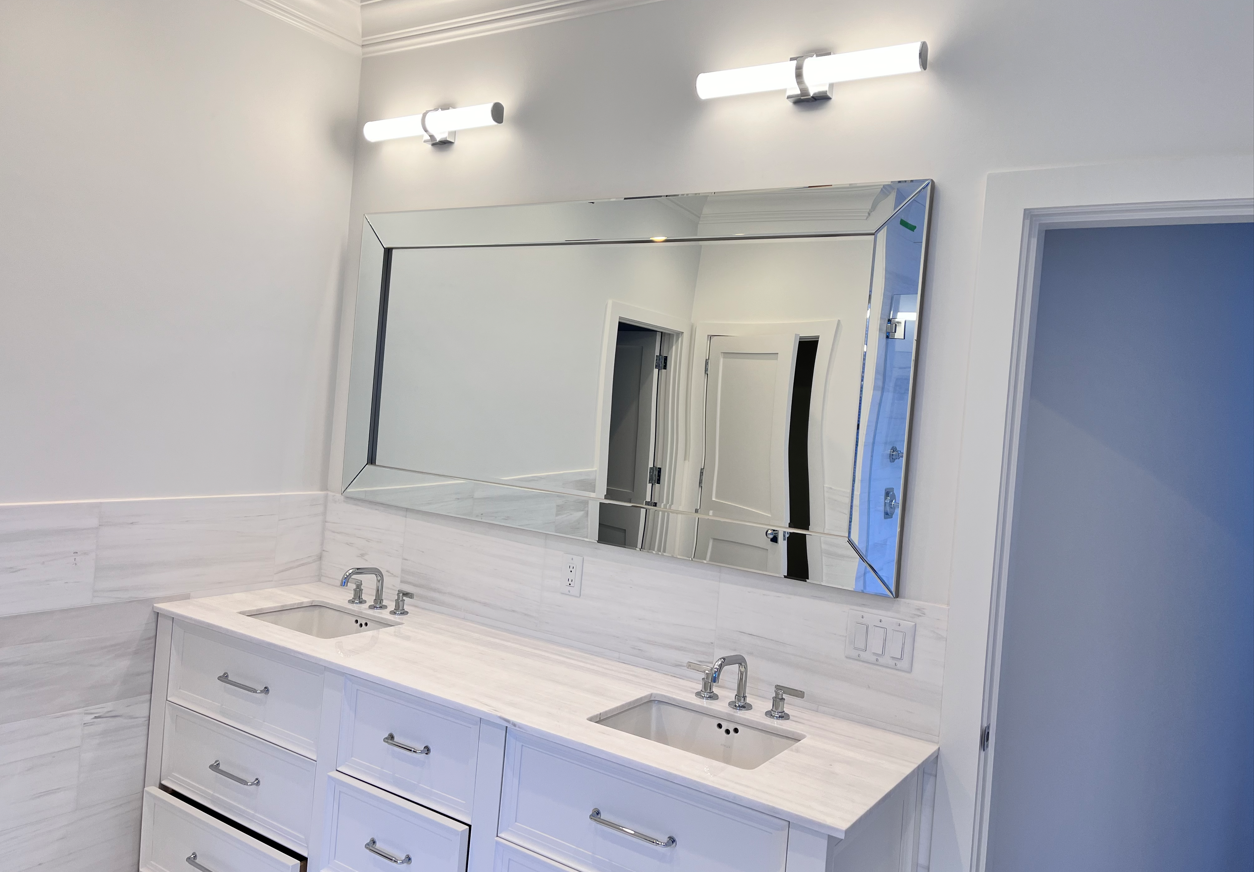 A bathroom with two sinks and a large mirror.