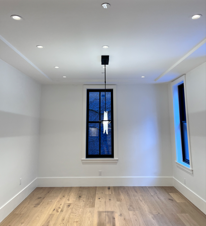 An empty room with hardwood floors and a window