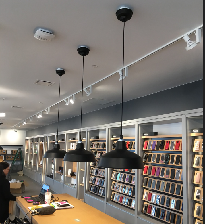 A store with a lot of shelves and lamps hanging from the ceiling