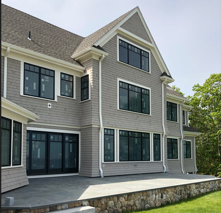 A large house with a lot of windows and a stone wall