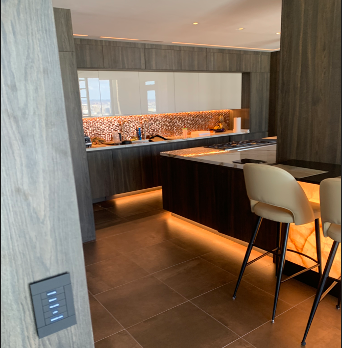 A kitchen with a table and chairs and a light switch on the wall