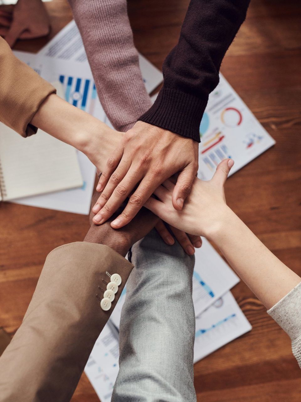 A group of people putting their hands together in a circle