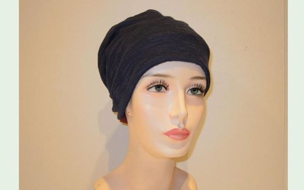 Manichino che indossa un berretto grigio scuro lavorato a maglia, in stile turbante.
