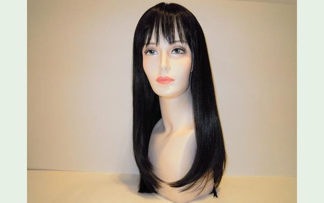 Parrucca nera con capelli lunghi e lisci e frangia su una testa di manichino.