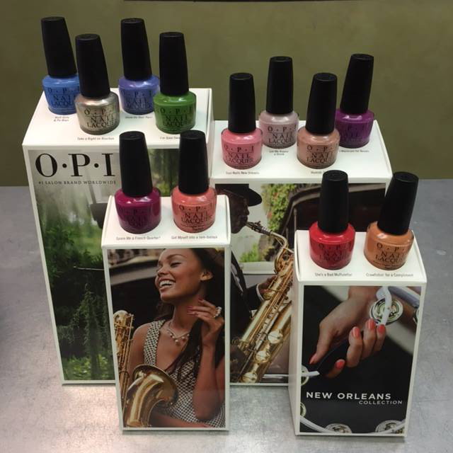 OPI nail polish bottles arranged on branded boxes, with assorted colors like blue, green, pink, red, and purple.