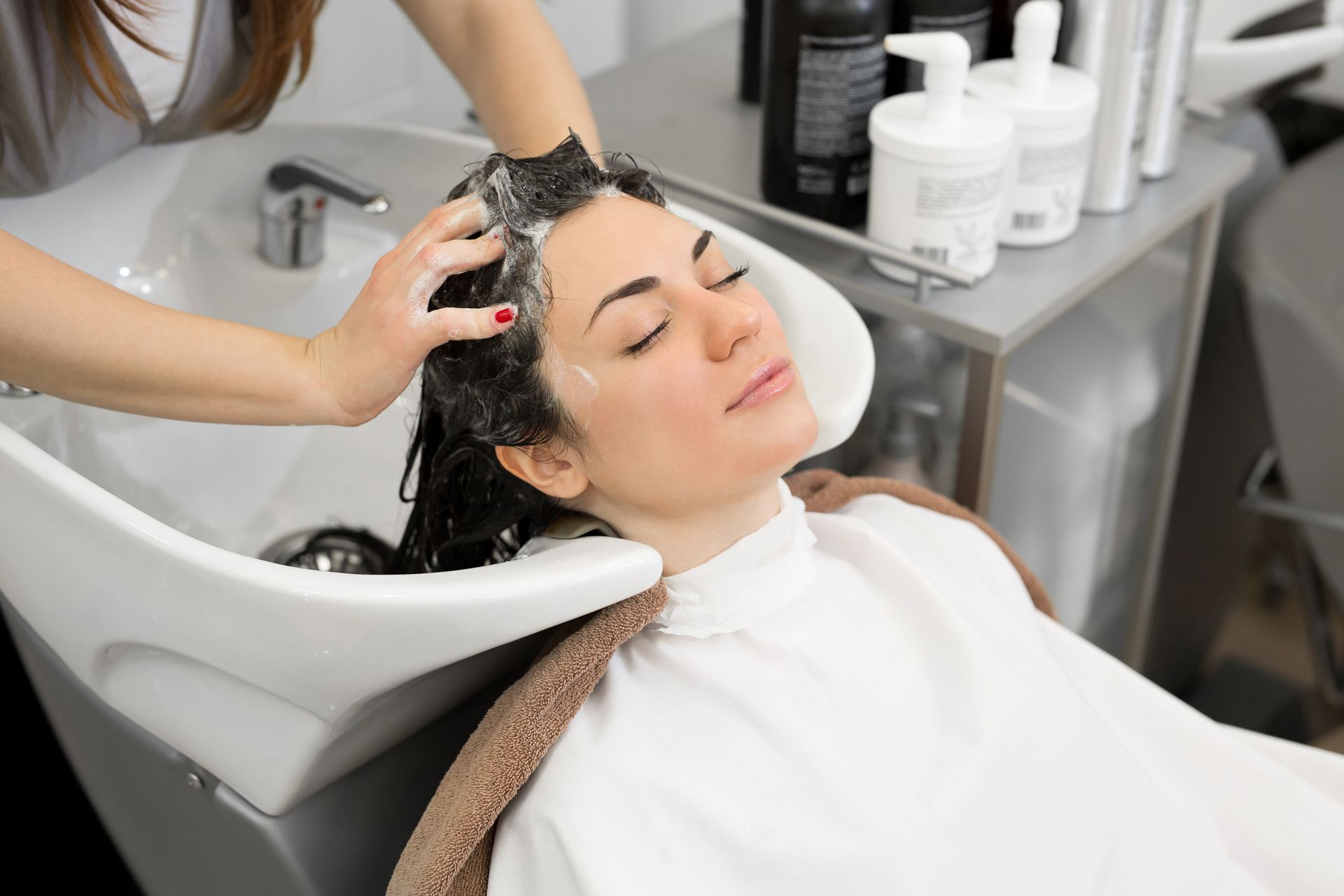 Woman having her hair washed at a salon shampoo basin