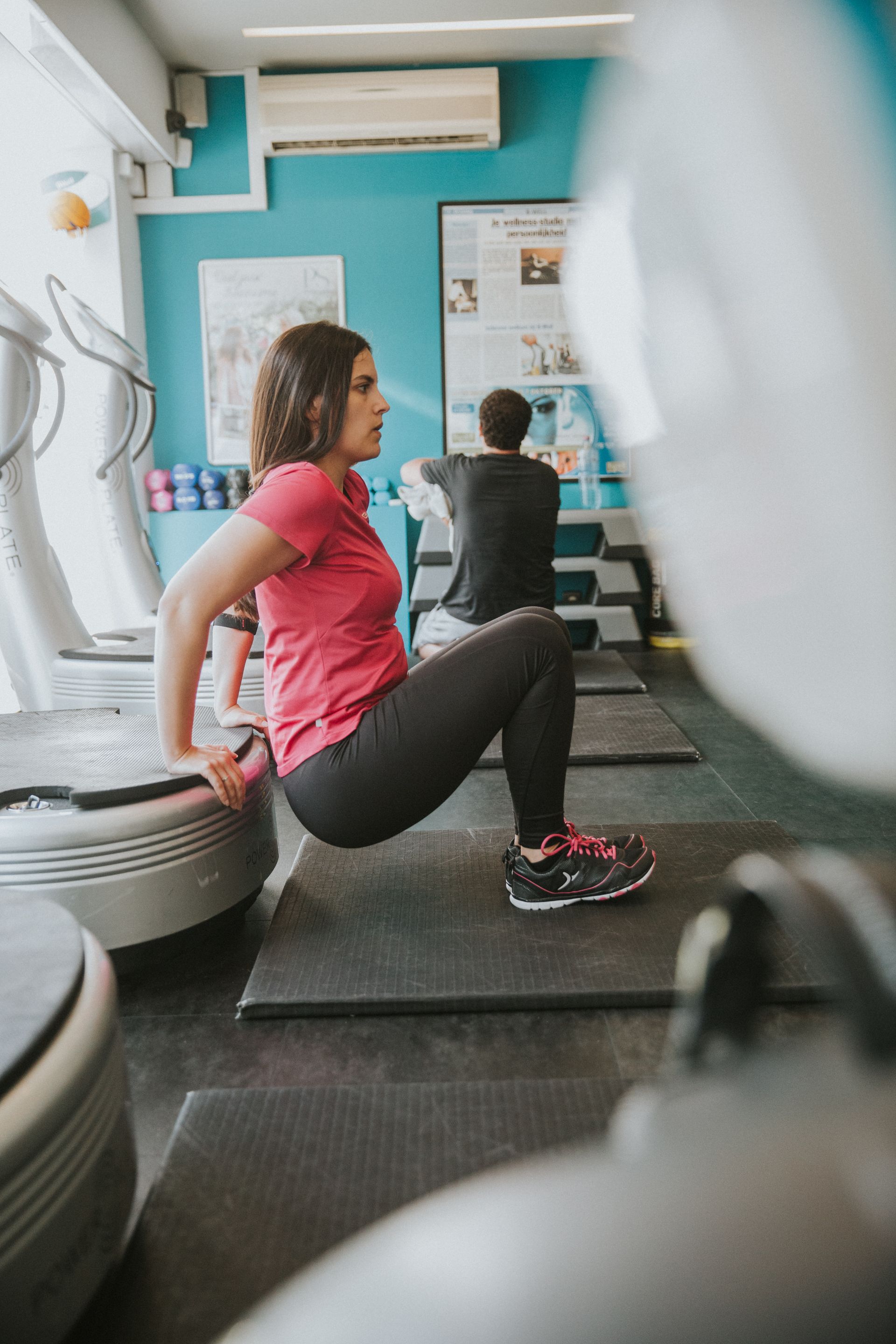 een vrouw doet dips op een platform in een sportschool.
