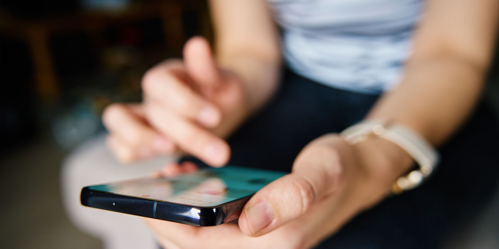 A woman is holding a cell phone in her hands.