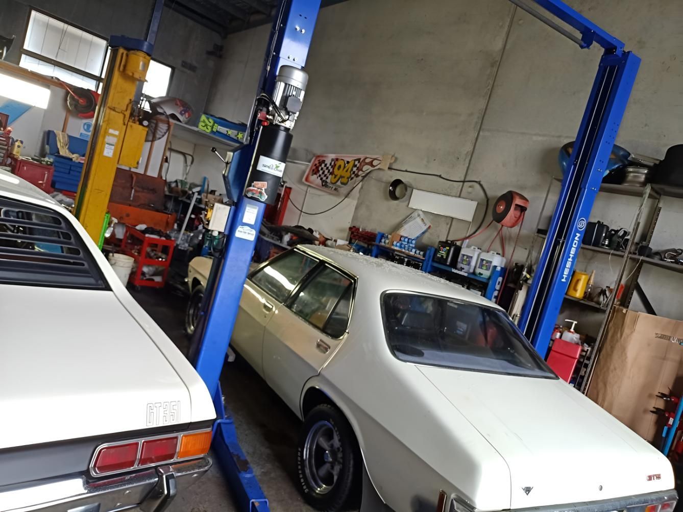 A White Car Is On A Lift In A Garage — Stanger Automatics In Ballina, NSW