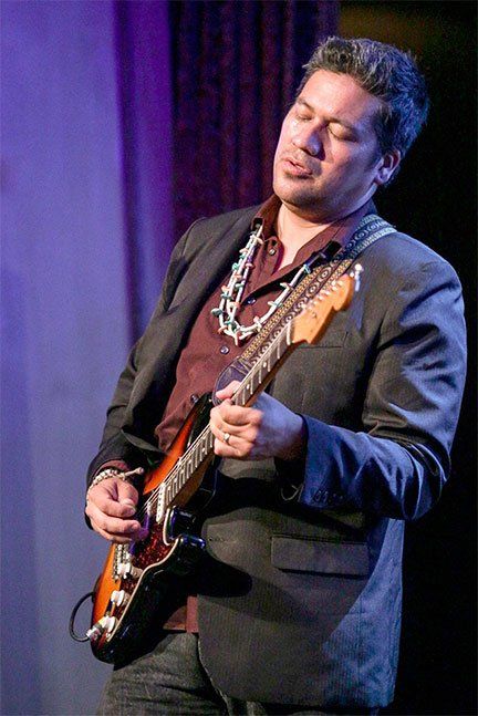 Image may contain guitar, man playing guitar
