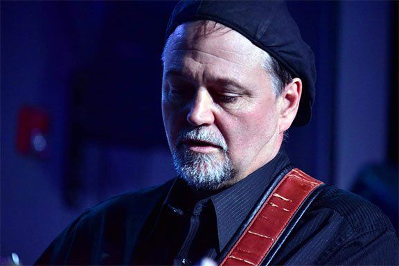 Image may contain guitar, man playing guitar