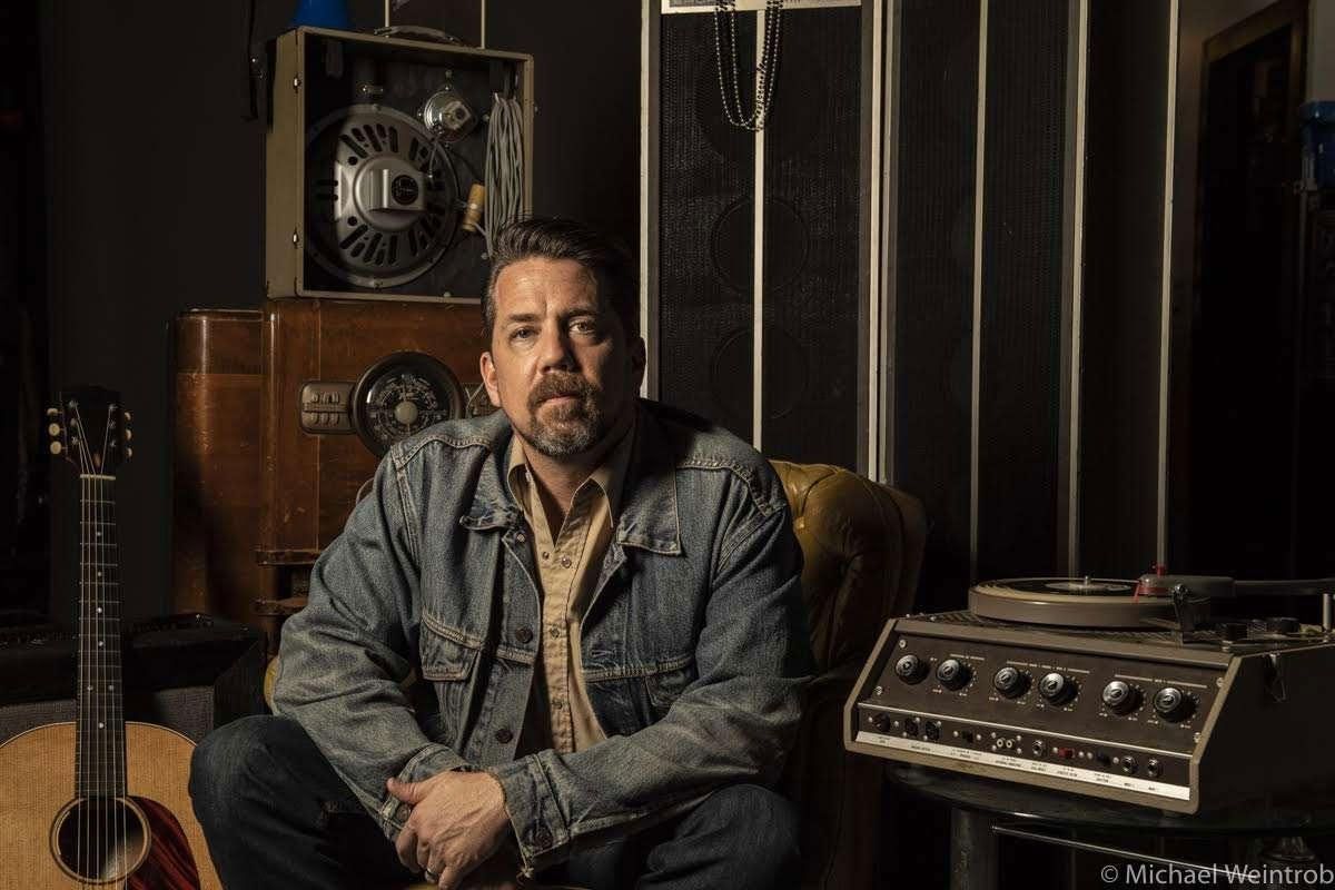 Image may contain guitar, man, speaker, record player