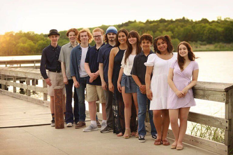 Image may contain group young people, lake, boardwalk, trees