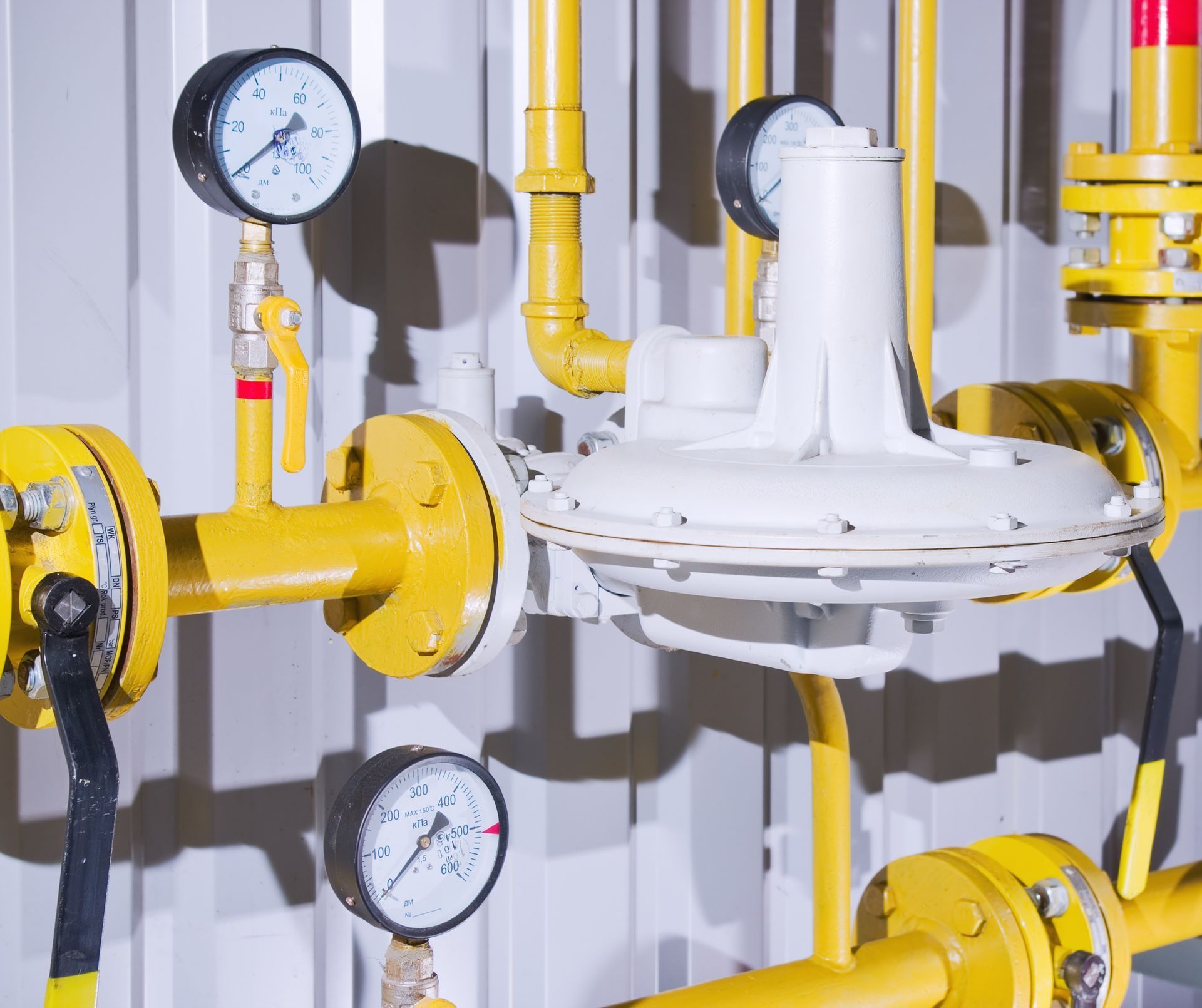 A bunch of yellow pipes with gauges attached to them