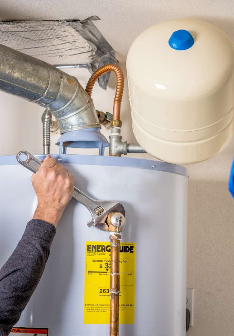 A person is fixing a water heater with a wrench.