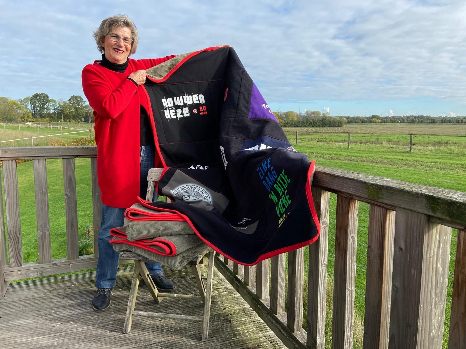 Ell Jans toont een herinneringsdeken, memorydeken van rowwen Heze, met rode stiksels en rood afgebiesd