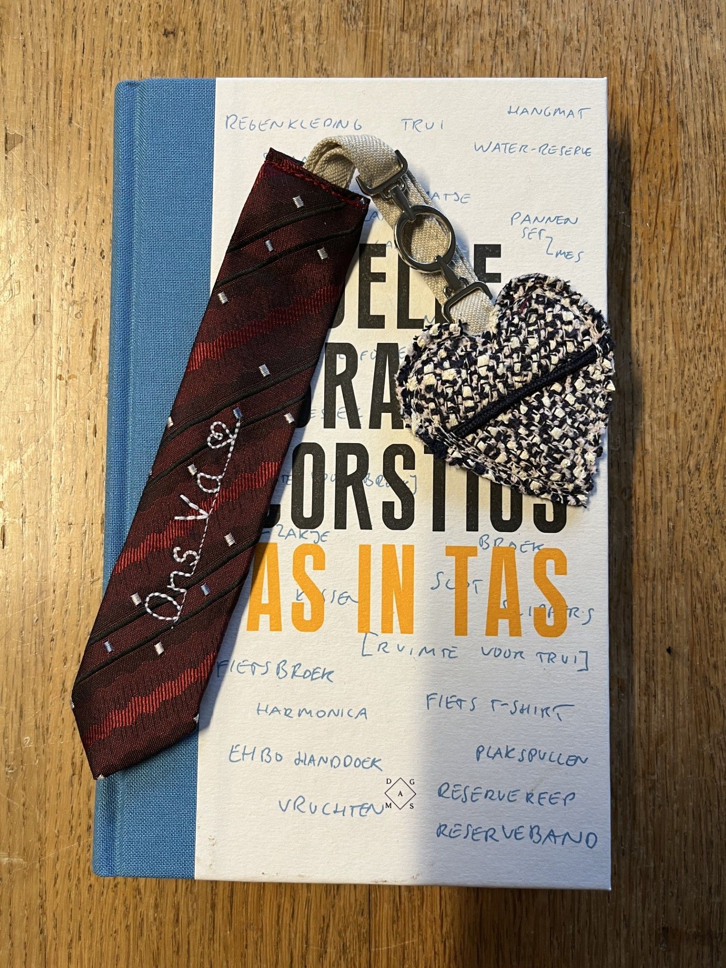 Van een rode stropdas met patroon werd een boekenlegger gemaakt een klein tastbare herinnering
