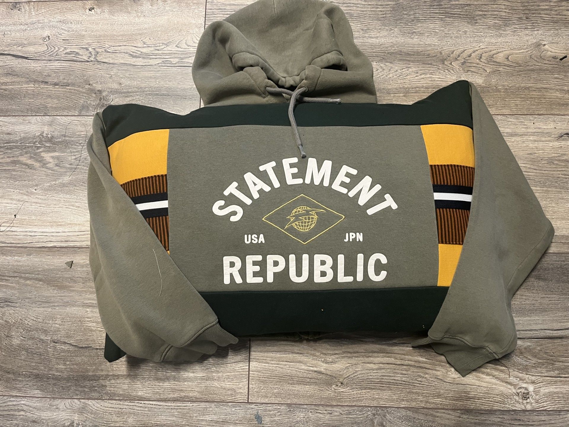 Van een olijfgroene hoodie is een herinneringskussen gemaakt in atelier Biezonder