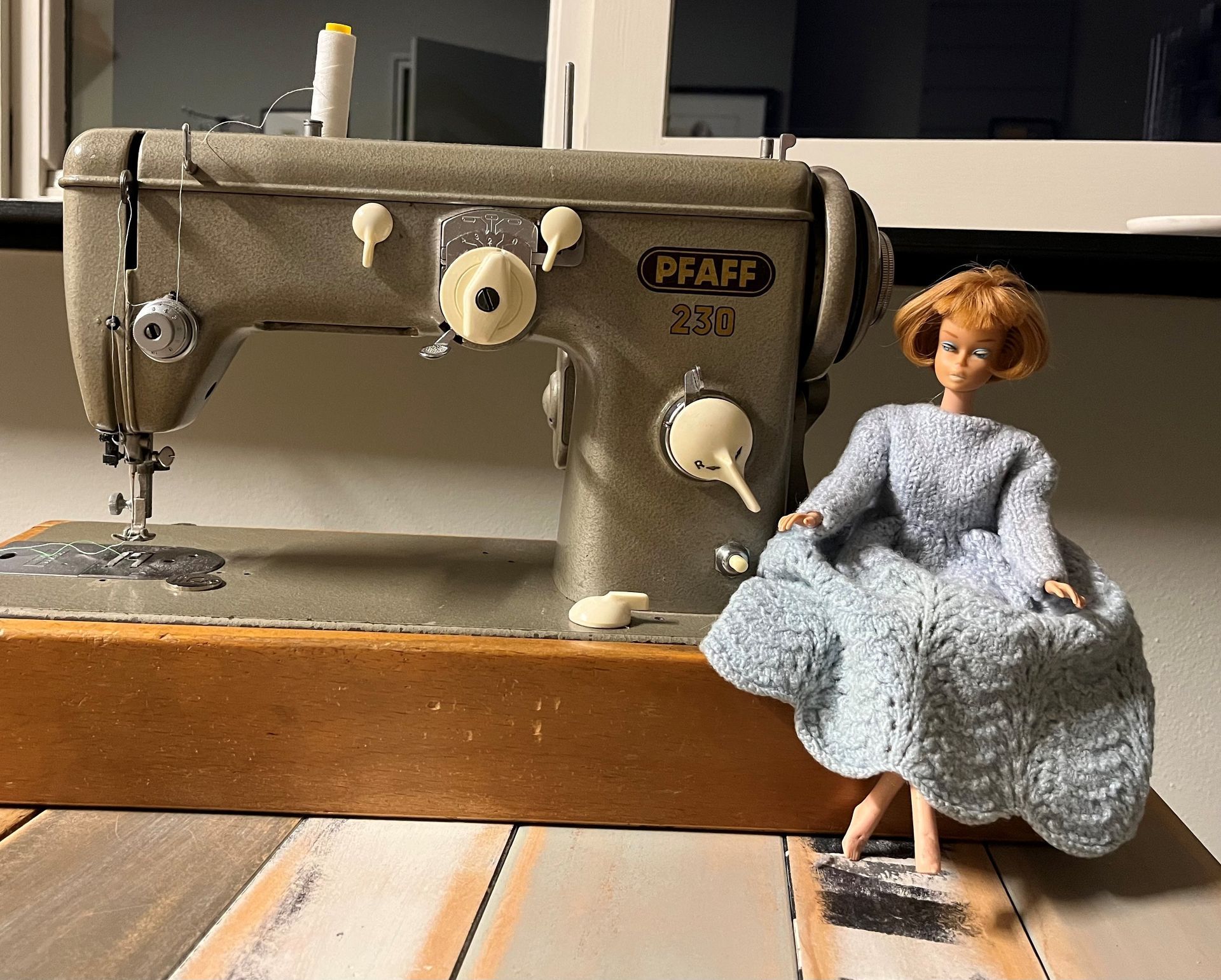 naaimachine met daarop een barbiepop met een door Ell Jans mooi gebreid jurkje