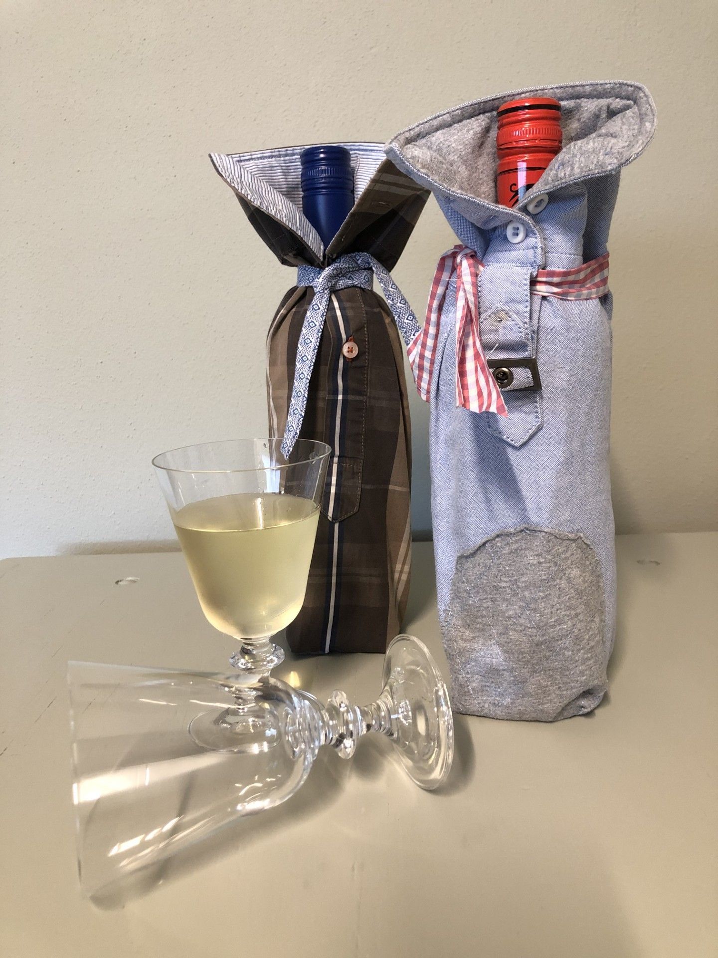 van een mouw van een overhemd een hoes gemaakt waar een fles wijn in kan, klein tastbaar aandeneken